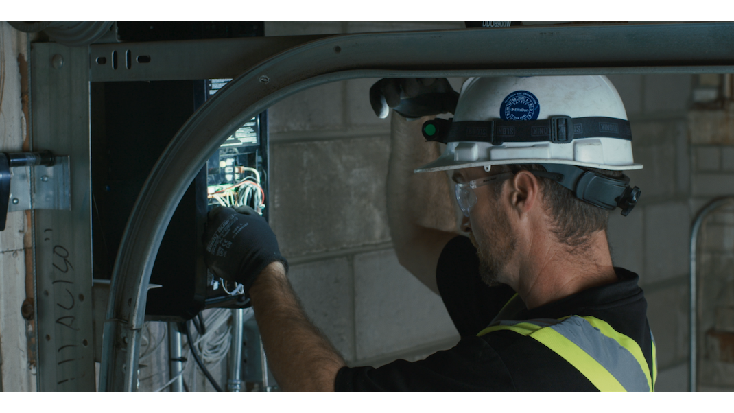 Door technician inspecting operator control switch