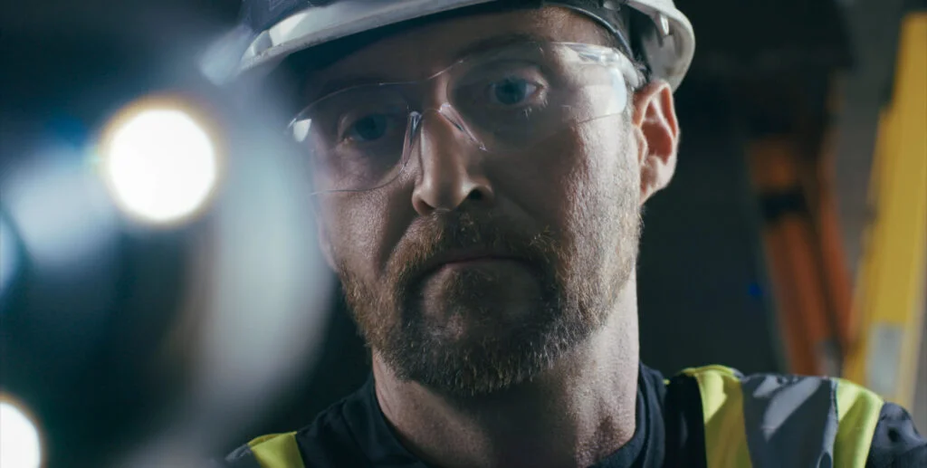 Wilcox technician in safety gear focused during commercial overhead door inspection