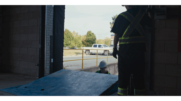 A technician performing commercial door repairs.